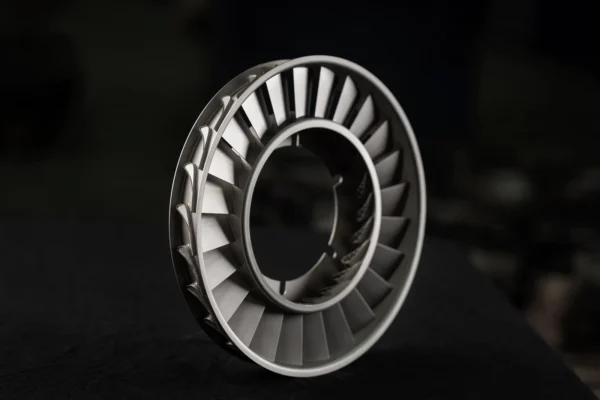 Mat gri metal türbin bileziği siyah fonda önden çerçevelenmiş, detay odaklı endüstriyel ürün çekimi.