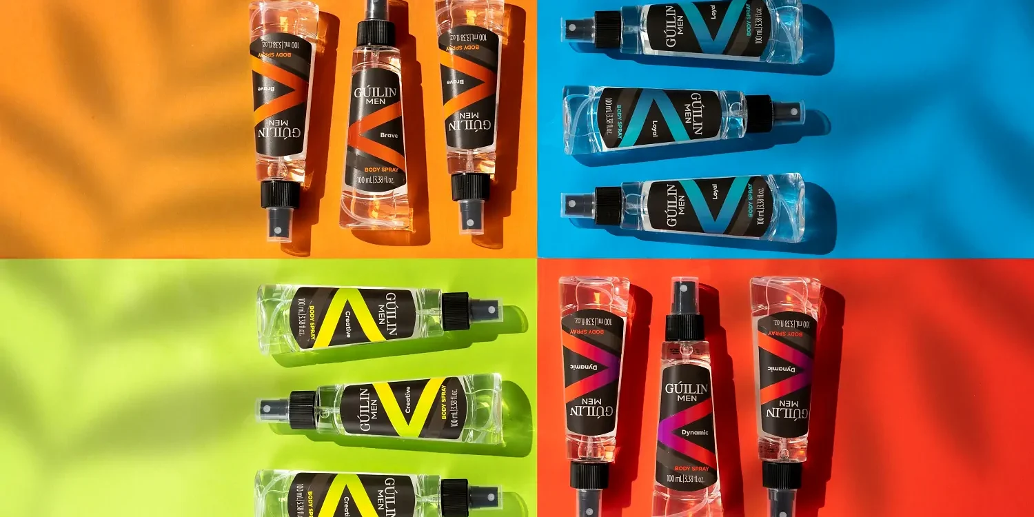 Turuncu, mavi, yeşil ve kırmızı blok fon üzerinde düzenlenmiş şeffaf vücut spreyleri, detay odaklı stüdyo ürün çekimi.