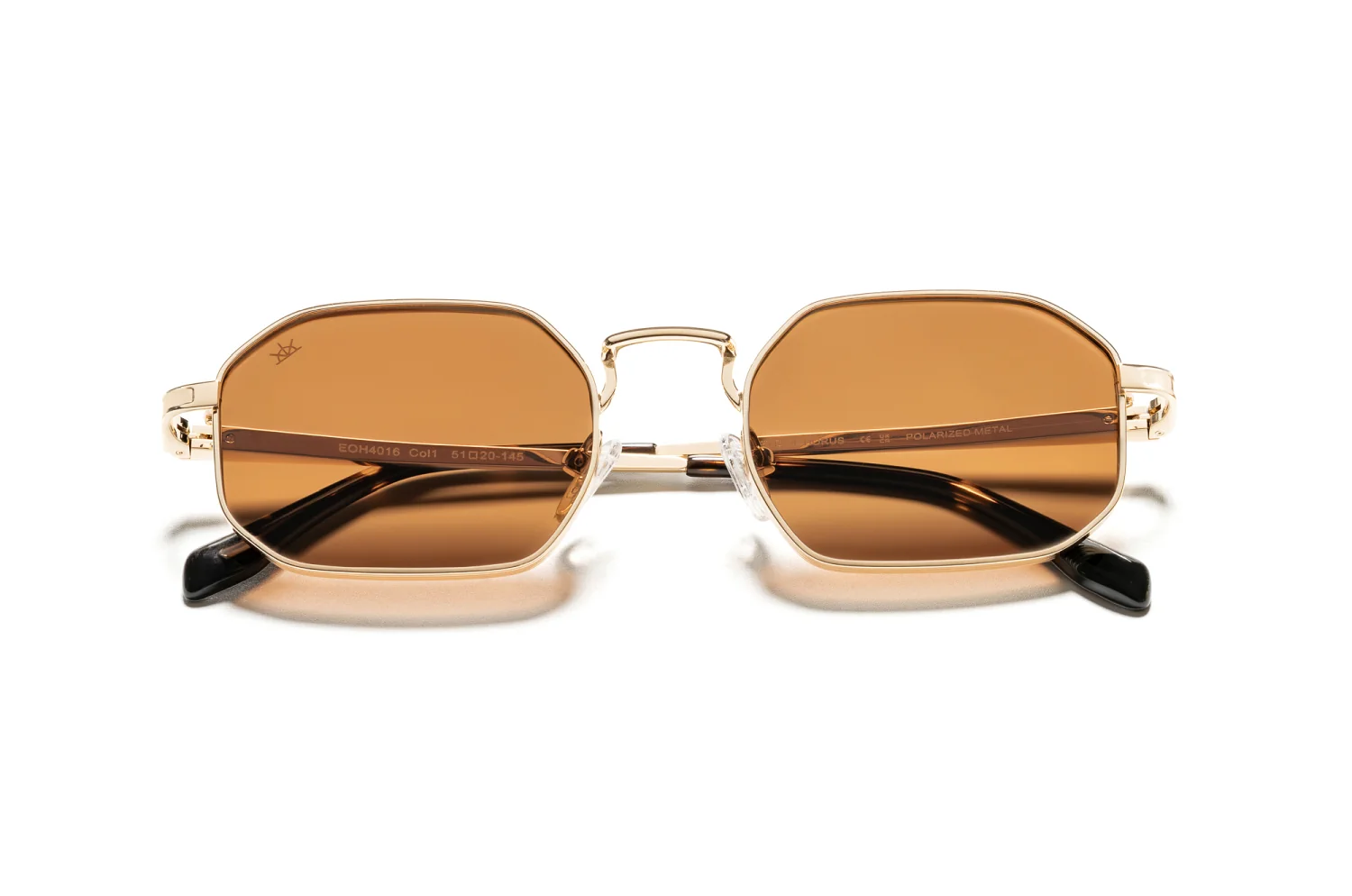 Brown-lensed sunglasses with a gold metal frame on a white background, sunglasses photo shoot